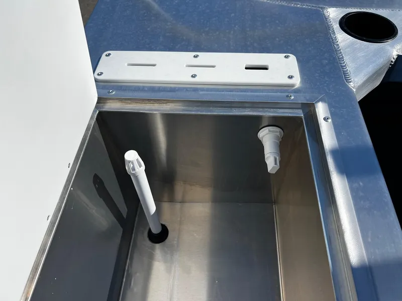 Slide: The Image of 2024 Thunder Jet 22 Alexis Pro boat storage compartment with drain and rod holder. - 25