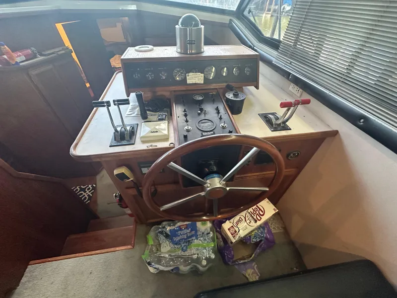 Slide: The Image of 1989 Carver 3807 Aft Cabin helm with steering wheel and control panel. - 16