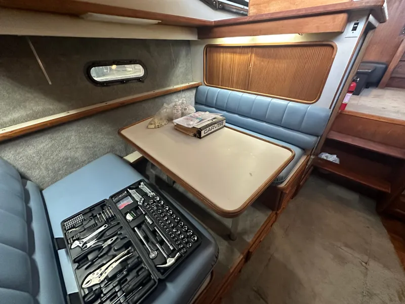 Slide: The Image of 1989 Carver 3807 Aft Cabin interior with dining area and toolset on table. - 21
