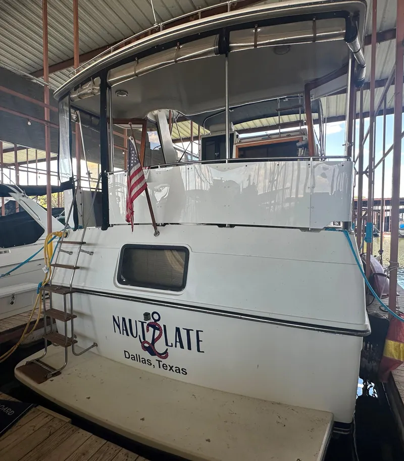 Slide: The Image of 1989 Carver 3807 Aft Cabin boat docked in Dallas, Texas with American flag. - 3