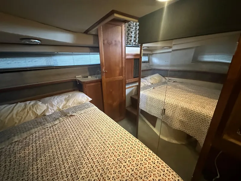 Slide: The Image of 1989 Carver 3807 Aft Cabin bedroom with mirrored closet and cozy bedding. - 31