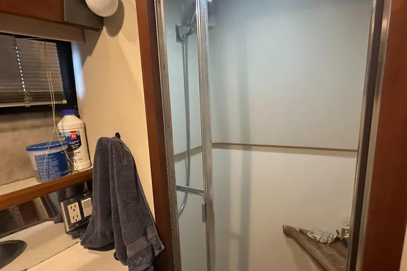 Slide: The Image of 1989 Carver 3807 Aft Cabin bathroom with shower, sink, and towel. - 35