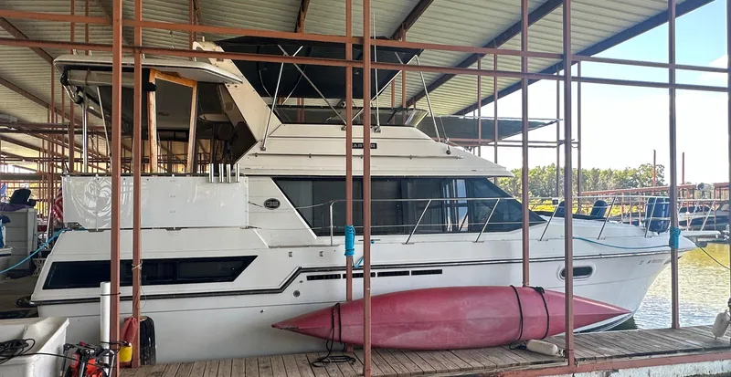 Slide: The Image of 1989 Carver 3807 Aft Cabin yacht docked with a red kayak alongside. - 7