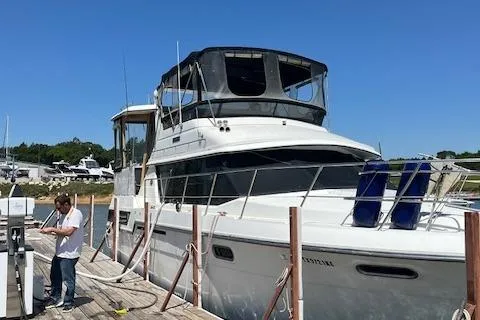 The Image of 1989 Carver 3807 Aft Cabin yacht docked at marina with a person on the pier. - 0