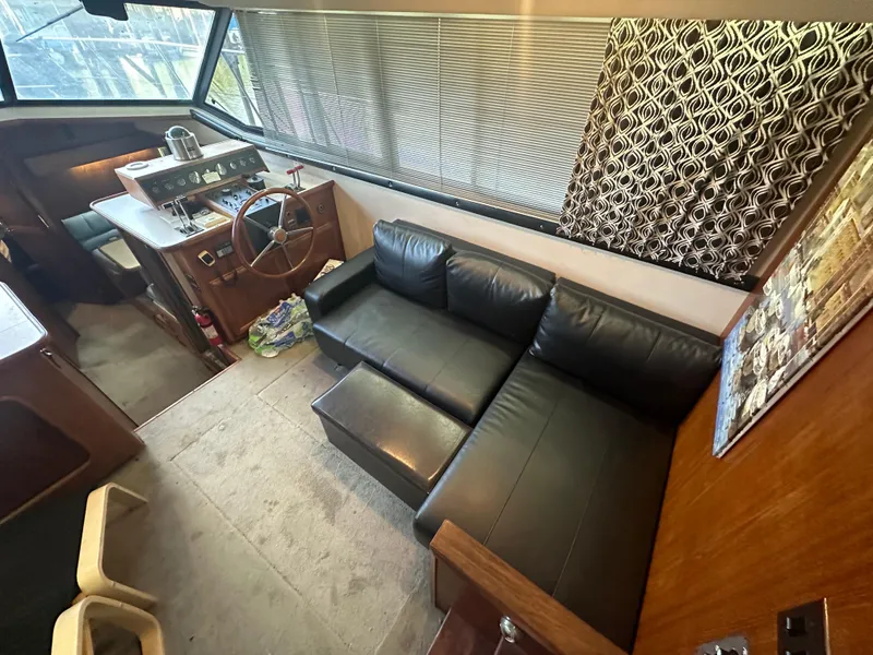 Slide: The Image of Interior of 1989 Carver 3807 Aft Cabin with black leather sofa and helm station. - 14