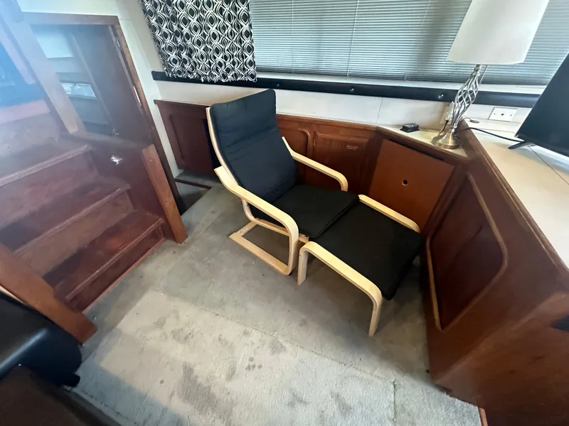 Slide: The Image of 1989 Carver 3807 Aft Cabin interior with modern chair and wooden accents. - 17