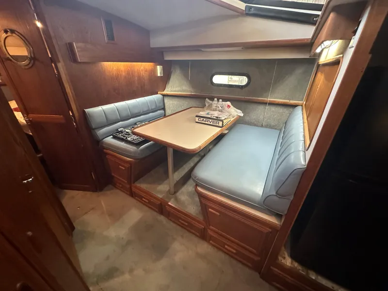 Slide: The Image of 1989 Carver 3807 Aft Cabin interior with cozy dining area and blue seating. - 20