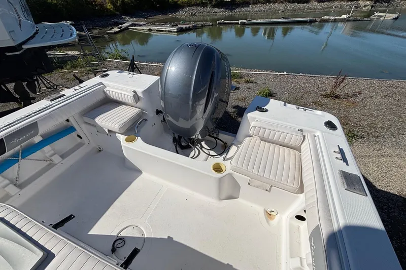 Slide: The Image of 2004 Pro-Line 20 Sport boat with outboard motor, docked by a calm river. - 11