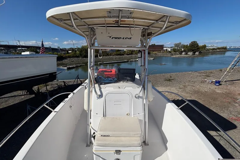 Slide: The Image of 2004 Pro-Line 20 Sport boat docked by a serene waterfront. - 6