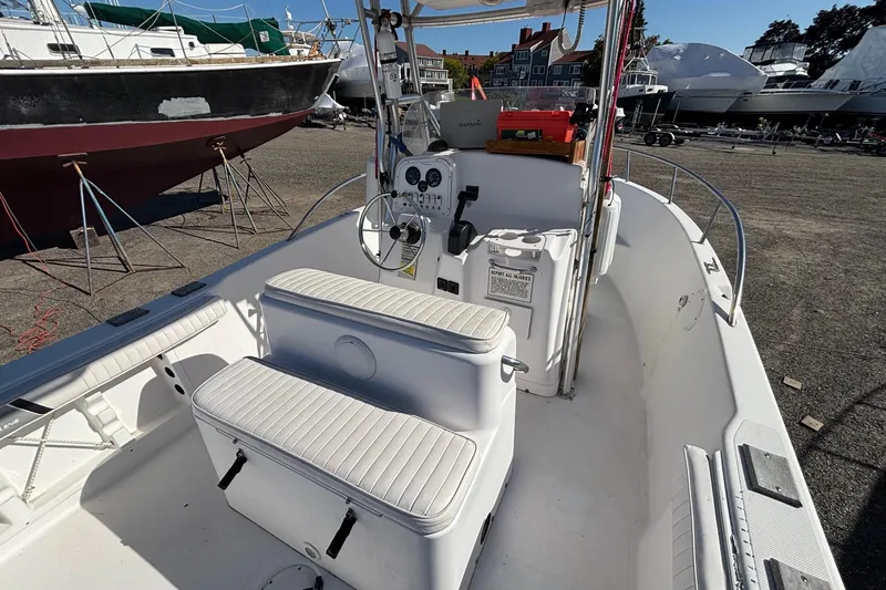 Slide: The Image of 2004 Pro-Line 20 Sport boat interior with steering console and seating, docked in a marina. - 8