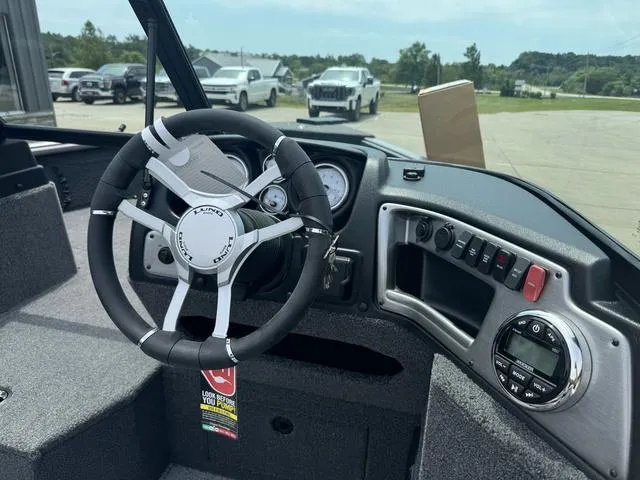 Slide: The Image of 2024 Lund 1875 Impact XS Sport boat dashboard with steering wheel and control panel. - 14