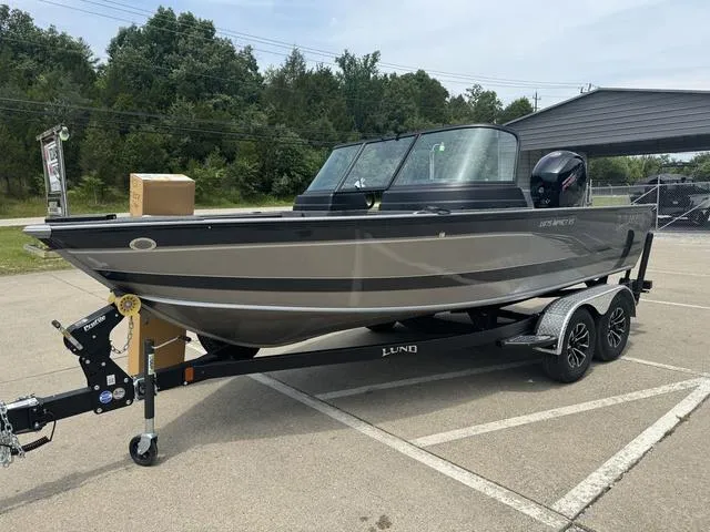 Slide: The Image of 2024 Lund 1875 Impact XS Sport boat on a trailer in a parking lot. - 8