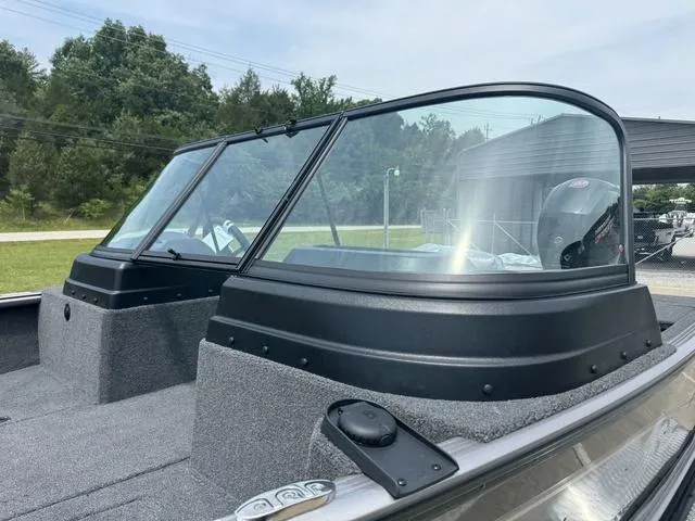 Slide: The Image of 2024 Lund 1875 Impact XS Sport boat with windshield, outdoor setting. - 9