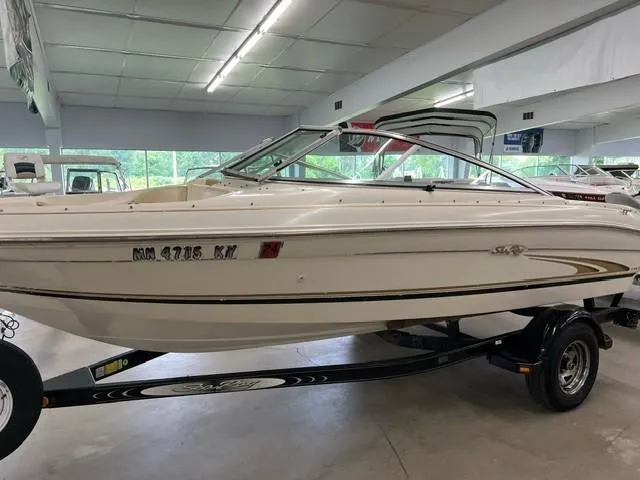 The Image of 2000 Sea Ray 185 Bow Rider boat on trailer in showroom. - 0