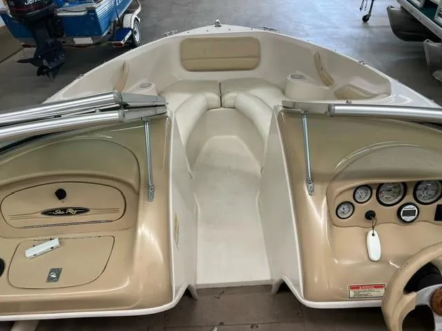 Slide: The Image of Interior of a 2000 Sea Ray 185 Bow Rider boat with beige seating and dashboard. - 10