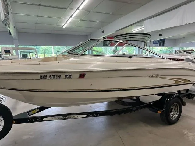 Slide: The Image of 2000 Sea Ray 185 Bow Rider boat on trailer in indoor showroom. - 2
