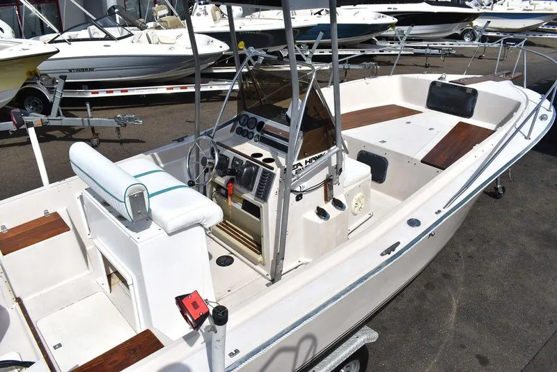 Slide: The Image of 1987 Chris-Craft 213 SeaHawk CC boat with center console and seating, docked in a marina. - 11