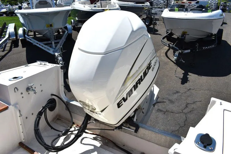 Slide: The Image of 1987 Chris-Craft 213 SeaHawk CC with Evinrude outboard motor in a boatyard. - 33