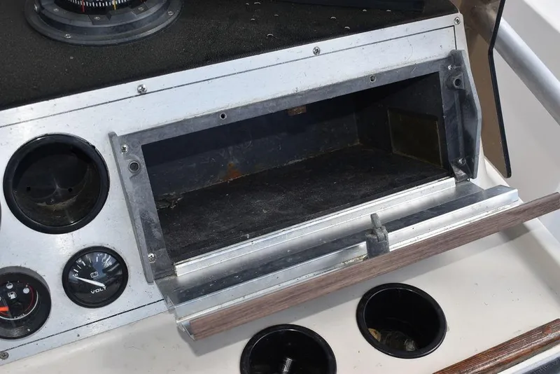 Slide: The Image of 1987 Chris-Craft 213 SeaHawk CC dashboard with open storage compartment and gauges. - 39