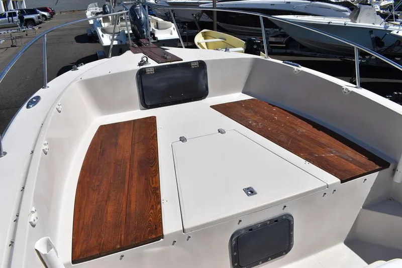 Slide: The Image of 1987 Chris-Craft 213 SeaHawk CC boat deck with wooden seating and storage compartments. - 40