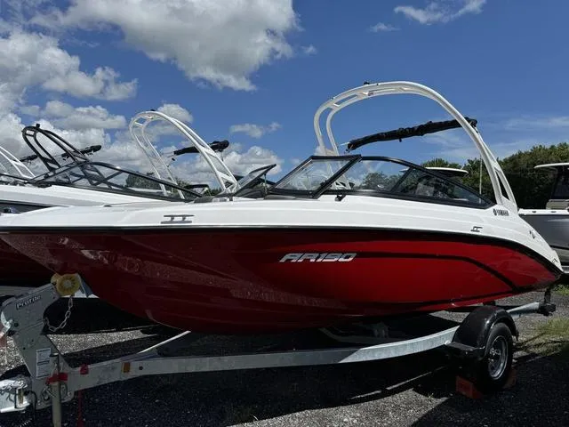 Slide: The Image of 2024 Yamaha Boats AR190 in red and white on a trailer under a blue sky. - 1