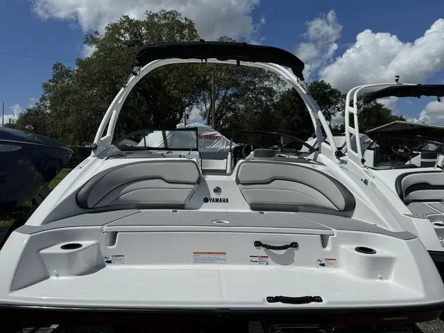 Slide: The Image of 2024 Yamaha Boats AR190, rear view, white and gray interior, docked under blue sky. - 3