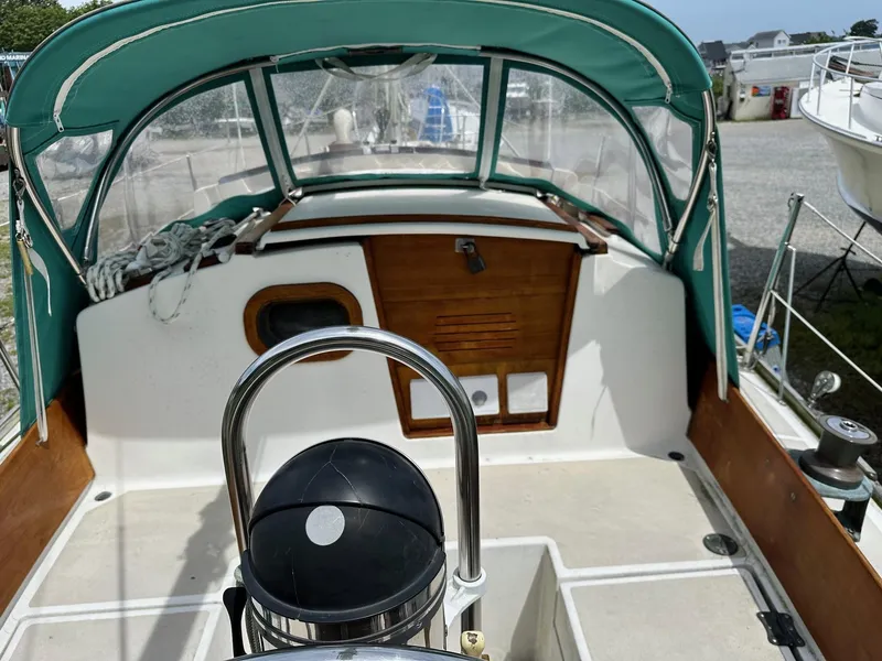 Slide: The Image of 1982 Cape Dory 30 sailboat cockpit with green canopy and wooden accents. - 11