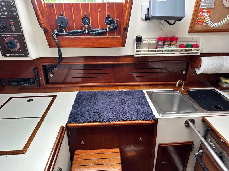 Slide: The Image of 1982 Cape Dory 30 yacht galley with sink, spice rack, and wooden cabinetry. - 14