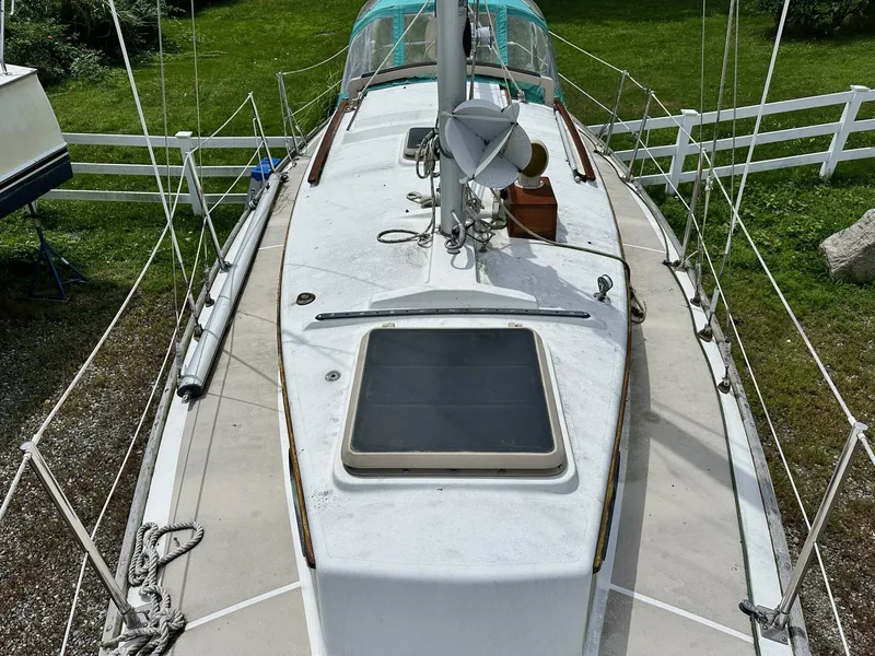 Slide: The Image of 1982 Cape Dory 30 sailboat deck view with green grass background. - 18