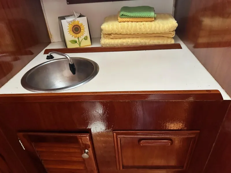Slide: The Image of 1982 Cape Dory 30 yacht interior with sink, wooden cabinetry, and folded towels. - 19