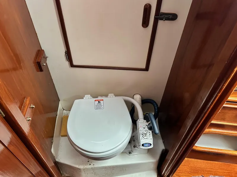 Slide: The Image of 1982 Cape Dory 30 sailboat bathroom with marine toilet and wooden cabinetry. - 20