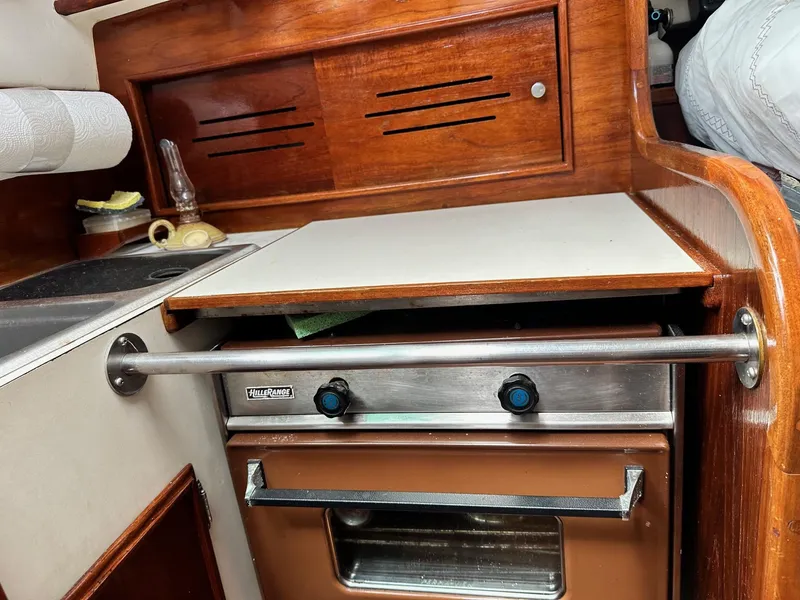 Slide: The Image of 1982 Cape Dory 30 yacht interior with stove and wooden cabinetry. - 23