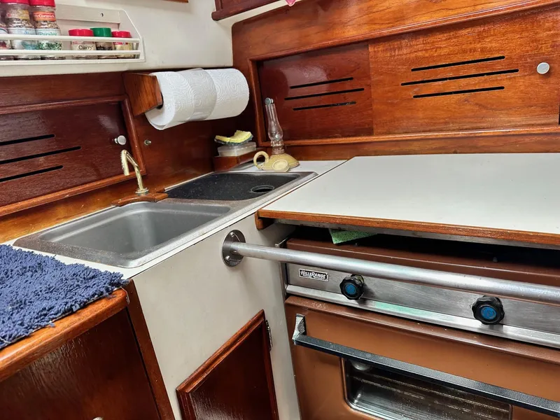 Slide: The Image of 1982 Cape Dory 30 sailboat galley with sink, stove, and spice rack. - 24