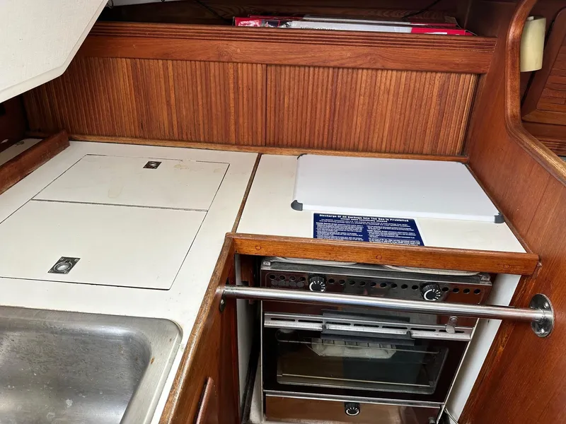 Slide: The Image of 1986 Sabre 30 Sabre MK III yacht galley with stove, sink, and storage compartments. - 13