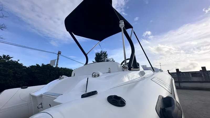 Slide: The Image of 2024 Aqvaboats LUXRIB 14 with canopy, sleek white design, outdoor setting. - 14