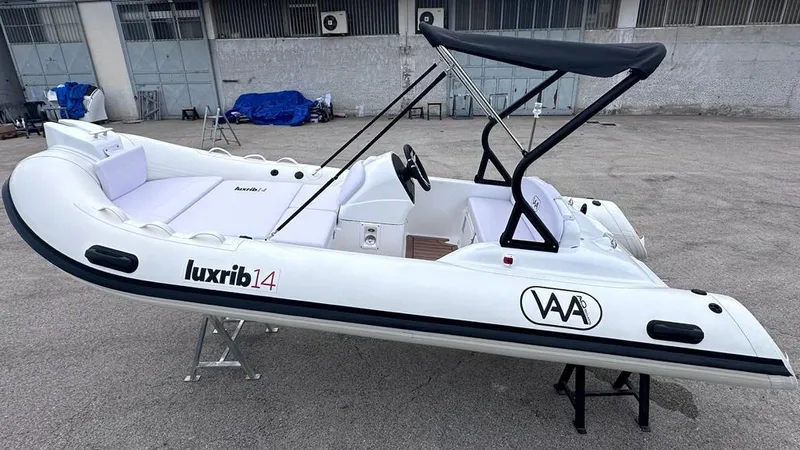 Slide: The Image of 2024 Aqvaboats LUXRIB 14 inflatable boat with canopy in a parking lot. - 2