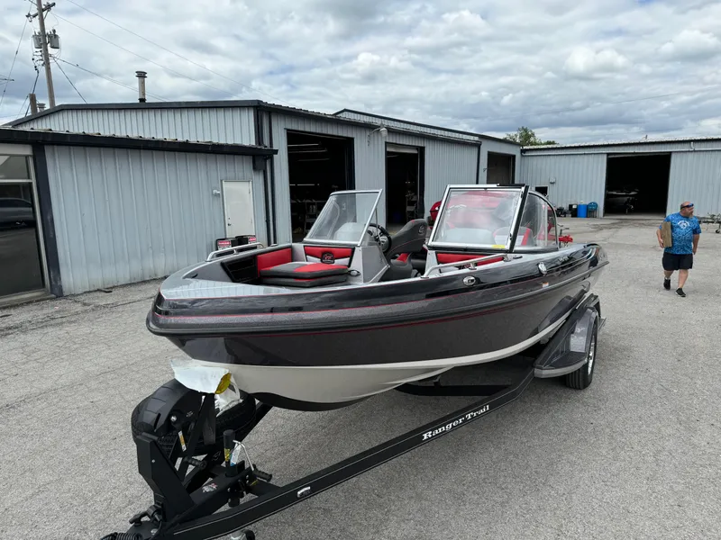 Slide: The Image of 2024 Ranger 1850MS boat on trailer outside a garage, under cloudy sky. - 8