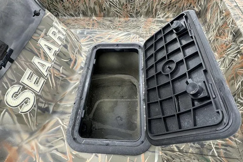Slide: The Image of 2025 SeaArk Shadow 17 Side Console with open storage compartment, camo design. - 17