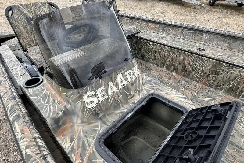 Slide: The Image of 2025 SeaArk Shadow 17 Side Console boat with camouflage design and open storage compartment. - 18