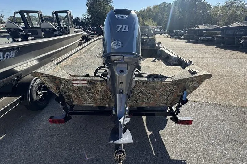 Slide: The Image of 2025 SeaArk Shadow 17 Side Console boat with 70 HP motor, camo design, parked outdoors. - 21