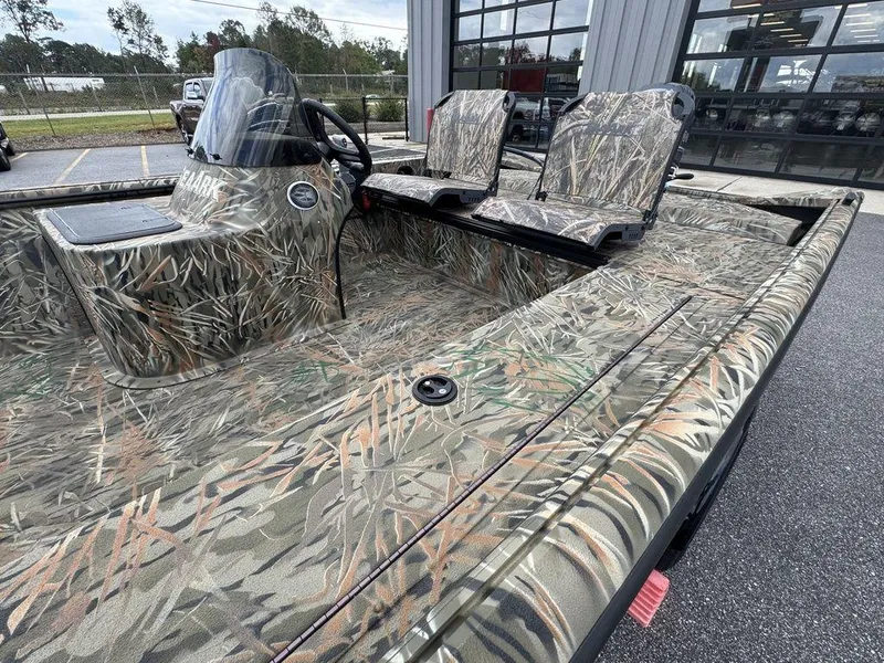 Slide: The Image of 2025 SeaArk Shadow 17 Side Console boat with camouflage design, parked outdoors. - 10