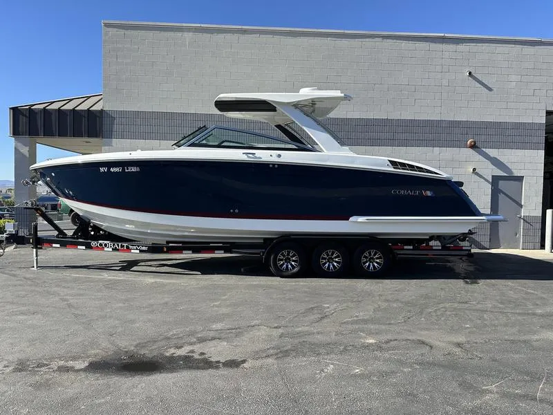 Slide: The Image of 2023 Cobalt R33 boat on trailer, parked outside a building. - 1
