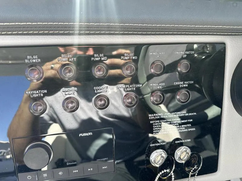 Slide: The Image of Control panel of a 2023 Cobalt R33 boat with various switches and audio system. - 18