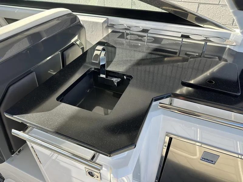 Slide: The Image of 2023 Cobalt R33 boat kitchen with sleek black countertop and modern sink. - 29