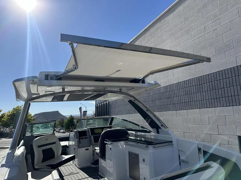 Slide: The Image of 2023 Cobalt R33 boat with open sunshade, sleek interior, and modern design. - 33