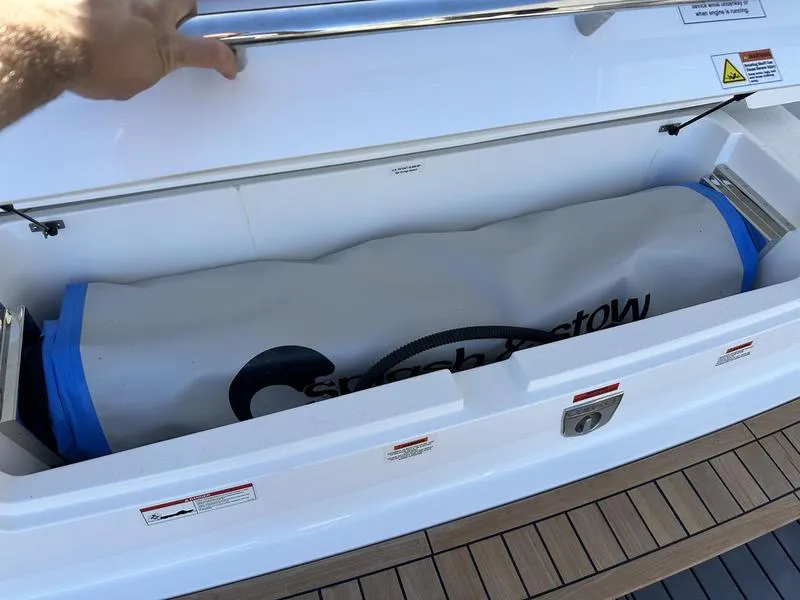 Slide: The Image of Cobalt R33 boat storage compartment with a neatly stowed inflatable item, 2023 model. - 36