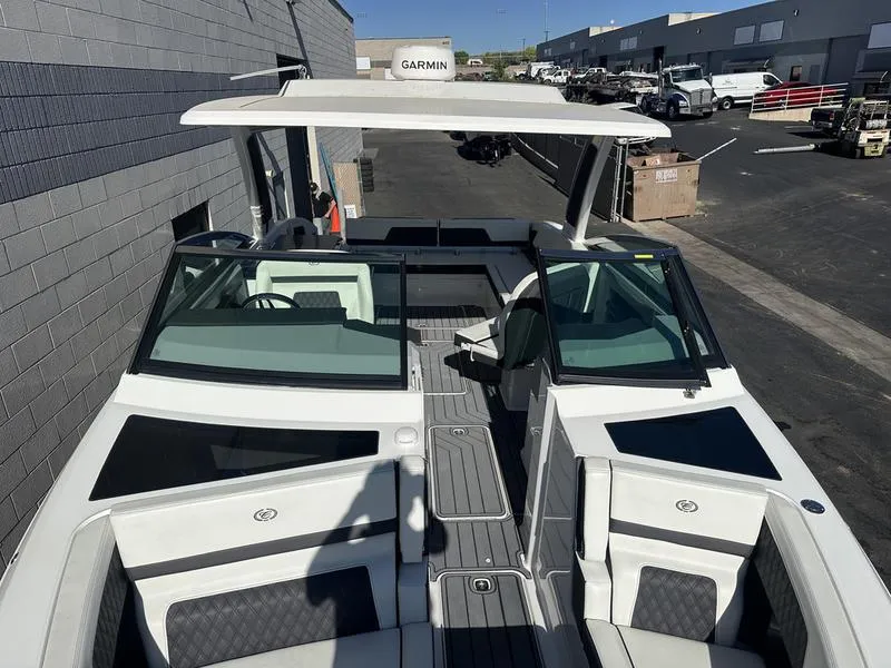 Slide: The Image of 2023 Cobalt R33 boat with sleek design, docked near industrial buildings. - 44