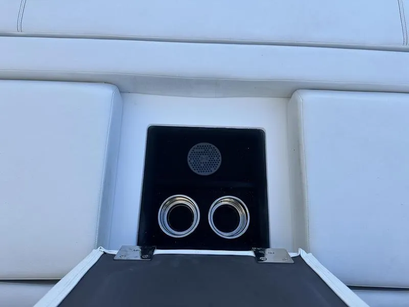 Slide: The Image of Cobalt R33 2023 boat interior with cup holders and speaker on white seating. - 46