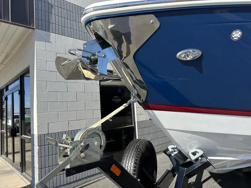 Slide: The Image of 2023 Cobalt R33 boat on trailer, blue hull, stainless steel anchor, parked outside building. - 5