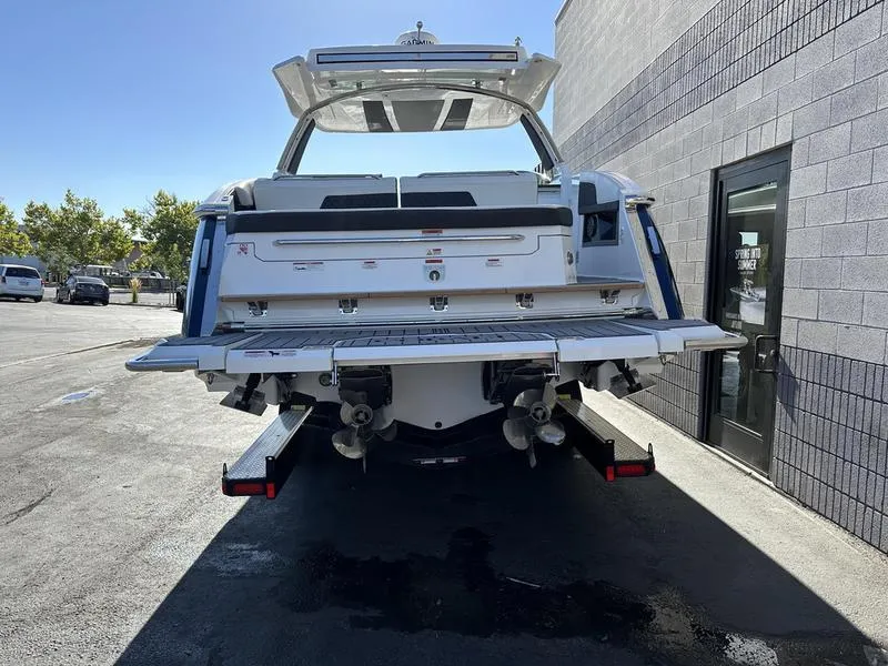 Slide: The Image of 2023 Cobalt R33 boat on trailer, rear view, parked near a building. - 7
